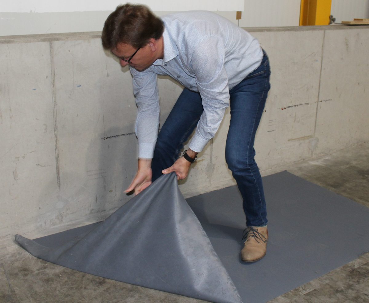 Grauer Fußboden-Abziehlack mit Gewebe wird vom Betonboden abgezogen